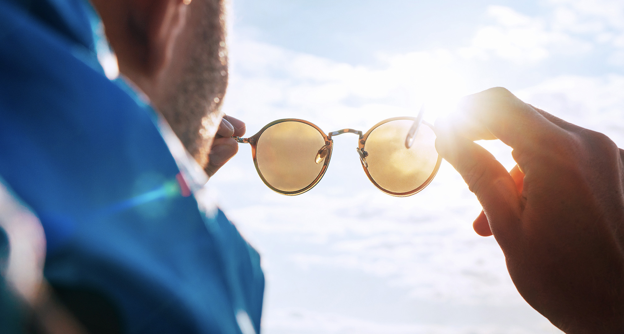 drži sončna očala proti soncu