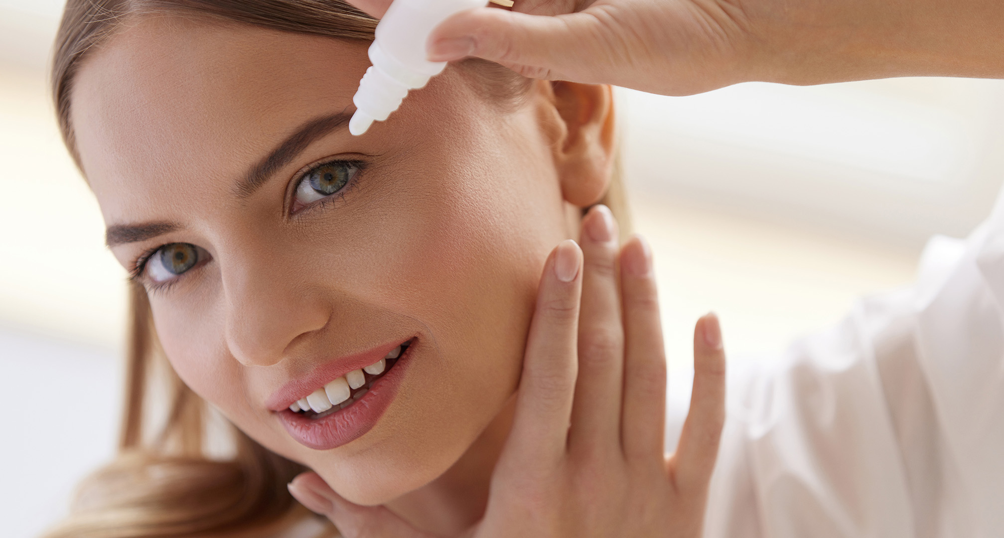 oseba, ki si daje kapljice za oči